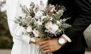 Un bouquet de mariée, roses pâles et feuillage, tenu par un couple. Peut-être une allusion à pourquoi on ne se marie pas en mai.