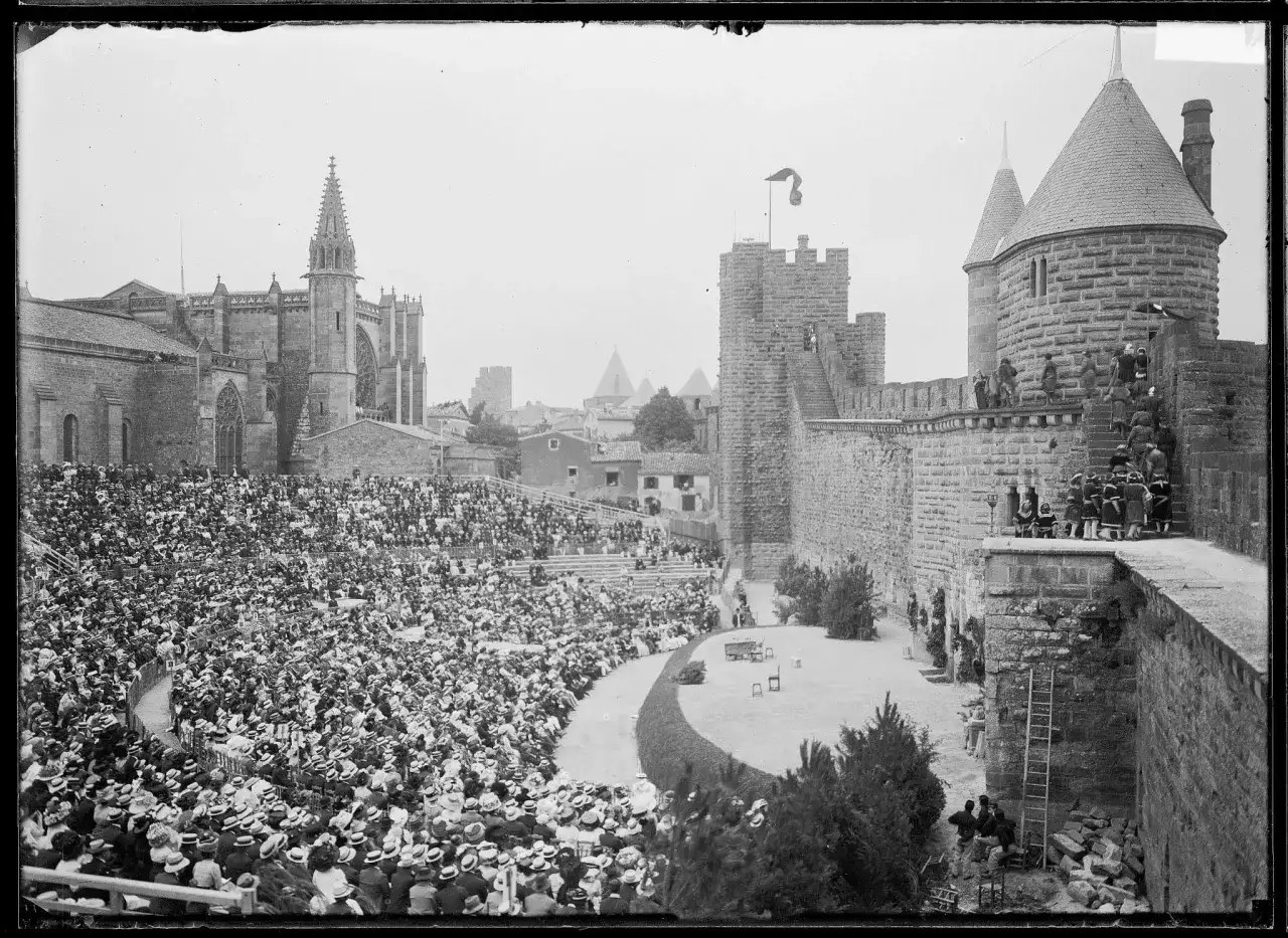 Vue d'un spectacle dans les arènes de Carcassonne, avec une foule nombreuse assise et la cité médiévale en arrière-plan.